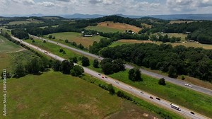 Beautiful mountain landscape in America's countryside with farmland and small towns with green trees under blue sky and clouds in Virginia, USA