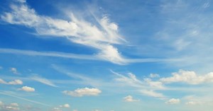Slowly moving cumulus clouds against a sky with high cirrus clouds.