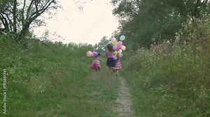 Girls with balloons running on a path