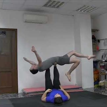 Acroyoga, woman lifts man on top