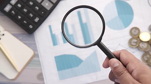 Analyzing financial data with magnifying glass Premium Stock Video Footage