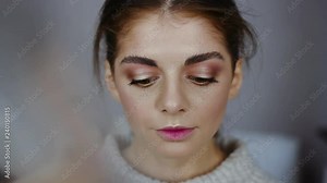 Beautiful young woman with make up big eyes look at camera seriously beauty face gorgeous glowing pretty fashion face female charming portrait model slow motion close up