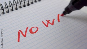 Text writing NO WAR in a notepad with a red felt pen. Protest against military aggression concept. Macro shot