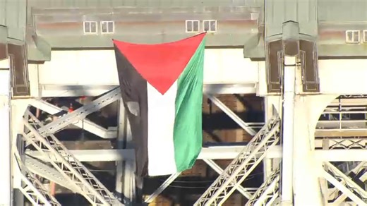 Large Palestinian flag waving from top of Williamsburg Bridge