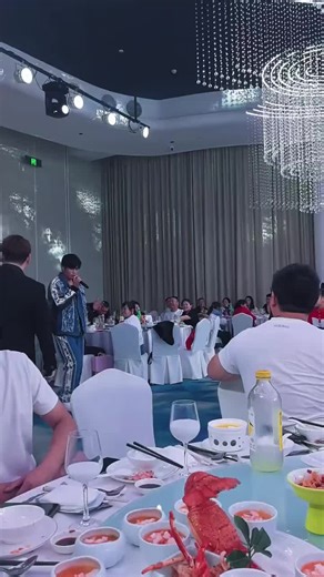 🇨🇳 他带着一种超然的静谧步入婚礼现场，步履中透着一种历经生命洗礼后的厚重与慈悲。他没有表现出任何执念，而是在悠远宁静的乐声中，从容地握住麦克风。他那充满智慧且沉稳的嗓音，在众人的注视下，向台下的新人投去温厚的目光，唱出了生命中最真挚的领悟： 🇬🇧 He enters the wedding venue with a transcendent stillness, his steps reflecting a depth and compassion gained through life's baptisms. Showing no attachment, he calmly holds the microphone amidst the serene music. With a voice full of wisdom and steadiness, he casts a warm gaze upon the couple and sings his most sincere realization of life: 🇨🇳「你们看，这满堂的繁华与此刻的盟约，都是命运在时