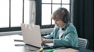 Excited overjoyed Teenager playing games on a modern laptop gadget at home. Little businessman kid boy using computer, playing computer games feeling joy and success. Videogames