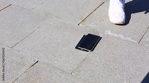 Mobile phone is falling on the ground and splits into parts, man's hand taking it off. Sensory phone falls on the ground and destroys.