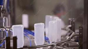 Sauce production line. Semi-transparent plastic bottles moving through the production line. Automatic line for processing of sauce.
