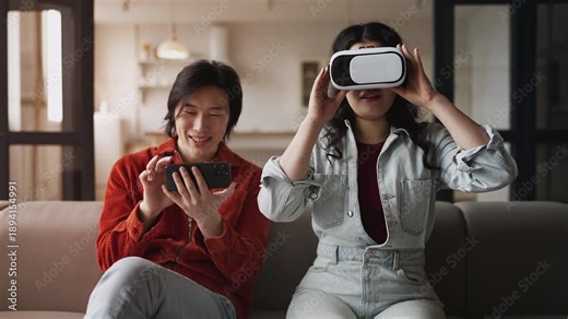 Young Asian couple experiencing virtual reality simulation using VR headset