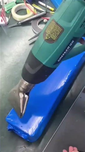 Using a heat gun to shrink and seal plastic wrapping tightly around a packaged item securely fast