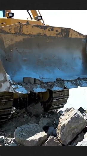 big dozer pushing the rock into water
