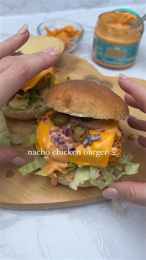 Nacho Chicken Burger 😮‍💨 A super quick and easy high protein chicken burger recipe for you to get your mouth around 🤌🏻. Crispy chicken fillet topped with cheese, nacho cheese sauce, red onion and jalapeños for the ultimate BANGING burger 🤤 Each burger is 461 calories and 40g protein ✅ Hit SAVE for your next burger night 📌💗 Ingredients (serves 2): 2 x 100g chicken breast Heaped tsp smoked paprika Heaped tsp garlic granules Heaped tsp onion granules Salt Pepper Egg whisked 40g crushed dorit