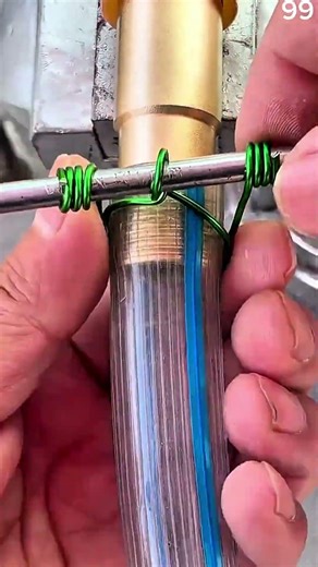 Green wire coils tightly around hose, securing brass fitting connection.