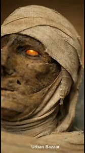 **Title:** The Throne That Remembers **Description:** In the pyramid’s hidden core, the alien steps forward and places a crystalline device onto the pharaoh’s ancient throne. The metal surface fuses seamlessly with gold and stone, as if the seat had always been waiting for it. Nearby, a mummy awakens — not in rage, but in recognition. A low vibration ripples through the chamber floor. The tremor is subtle, rhythmic. Lines of light begin spreading outward from the throne, traveling along carved c