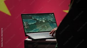 Chinese soldier in command control room using military tech to identify threats from enemies. Army personnel using software on laptop to communicate information to generals on war front line, camera A