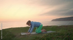 Senior woman practicing yoga asanas on beach. Pensioner woman practicing yoga stretching her body ocean background during sunset. Concept wellness, healthy senior lifestyle, yoga poses