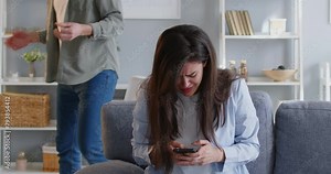 Woman stressed frustrated typing on phone man angrily takes away phone from womans hands couple quarrel. Couple quarrel scene negativity unresolved emotions Couple quarrel angry frustration negative