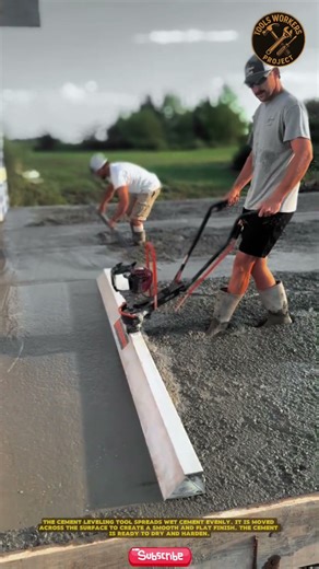 Construction workers use a powered concrete leveling machine, or power screed, to level and compact