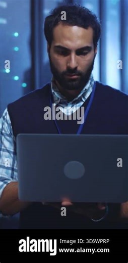 A dedicated man is deeply engrossed in his laptop, set against the backdrop of a sleek, modern office space Stock Video Footage - Alamy