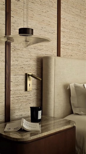 MASOOMEH HILAL DESIGN on Instagram: "For our Garhoud 28 project, we layered modern lines with warmth , textural wallpaper to soften the space, custom bedside tables finished in marble, and elegant Artemest pendant lights paired with discreet reading lights for everyday comfort. A cozy seating corner completes the room, where the clients’ existing chairs were refreshed with Pierre Frey fabrics, giving them new life and purpose. A space made to slow down, unwind, and truly feel at home. 🖤 XMH #ma