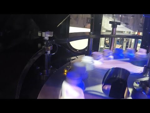 Videojet 7810 UV laser marking on HDPE bottles in rotary transport system