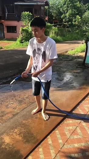 Outdoor Water Fun: Spraying with a Blue Hose