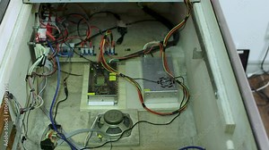 Interior wiring and components of a pinball machine, showcasing cables, power supplies, and speaker layout.