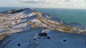 Scenic aerial view of a frozen valley in Iceland surrounded by mountains covered with snow and ice. Snow Mountain in Iceland. Aerial view and top view. Icelandic Nature and Landscape