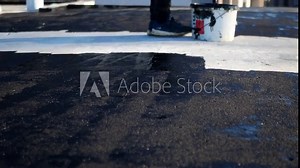 Flat roof waterproofing preparation using mastic primer close up by professionals