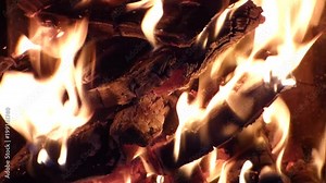 Fire background - red hot glowing flame inside stove. Closeup view of furnace or campfire. Burning firewood and charcoals. With original sound.