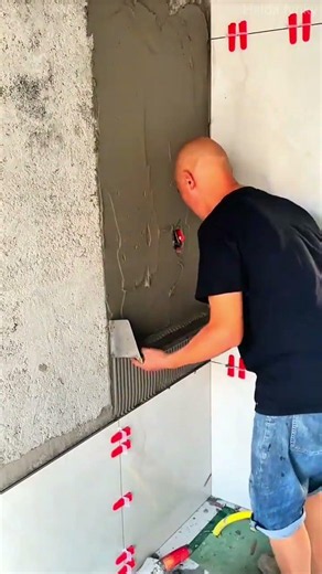applying cement mortar smoothly onto a concrete wall using metal trowels for installing tiles