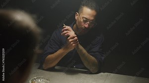 Police asking suspect questions in interrogation room