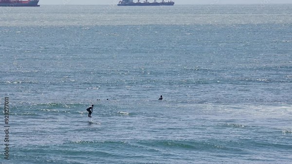 People surf water sport near shore, sea ocean water surfing in wetsuit
