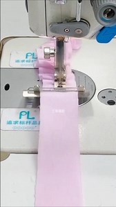 sewing machine creating gathered fabric, also known as ruffles, on a light pink garment.