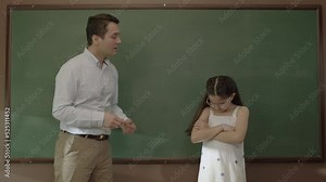 Young teacher teaching math to female student at the blackboard in the classroom. Portrait of an idealistic teacher who wants to help her student prepare and succeed for exams. Successful teacher.