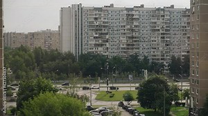 High-rise apartment buildings and a busy highway next to them. Transport is moving along the highway