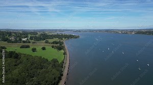 River Exe, South Devon, England: DRONE VIEWS: The River Exe and boats; the mainline railway line heading to Exeter (left) and a distant view of Powderham Castle (left).