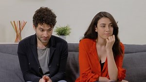 jeune couple timide assis sur un canapé dans le salon donnant un baiser sur la joue.Premier, date, tombe amoureux, timidité