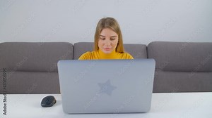 Beautiful white woman working on laptop computer. Professional freelancer person doing distant work from home during lockdown. Blonde Caucasian female typing on notebook pc in 4k stock video clip