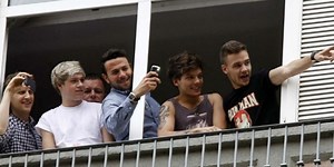 One Direction complace a fans al saludar desde la terraza