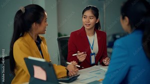 Business professionals brainstorm and discuss documents in a collaborative meeting. Colleagues exchange ideas and work together on project plans