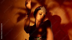alluring woman in shiny arabic clothes is dancing seductively oriental dance in night