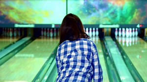 Download Girl knocks down pins at the bowling for free