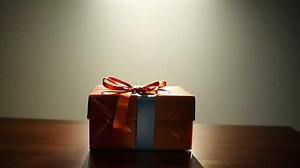 Download Gift Box with Orange Ribbon on Table. for free