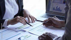 business partners working with laptop computer together analysing startup financial project result or strategy plan and discussing data document in office.