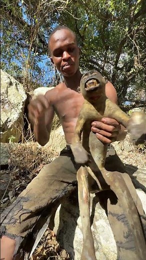A hungry hunter cooking traditional baboon meat in the bush