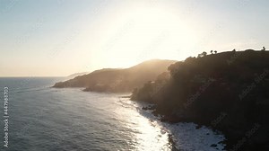 Drone Flying above Coastline alongside Cliffside with Pacific Ocean Water following the Sun rays During Sunset. Cinematic Drone Footage. La Libertad, El Salvador