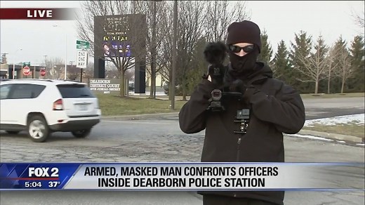 While Amy Lange Fox 2 was live reporting on the masked armed open carry advocates who were arrested for walking into the Dearborn police station Sunday, one of them appeared to be filming his own report. | FOX 2 Detroit