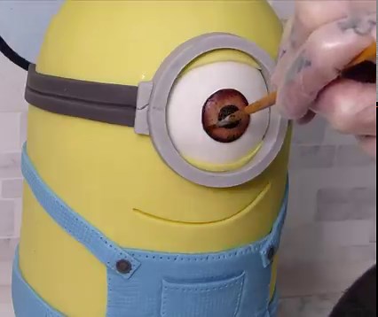 745K views · 15K reactions | Making a Minion out of Chocolate CAKE  I user Layers of Chocolate sponge Cake, White Chocolate ganache, & Sugar-paste detailing! I absolutely Love him  | The BakeKing | Facebook