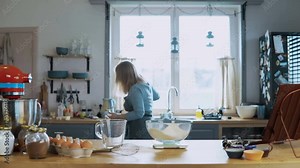 Young attractive woman cooking in the kitchen at home. Beautiful housewife preparing the meal, using kitchen scales.